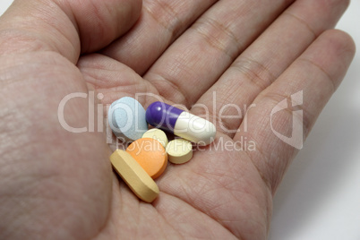 hand holding assorted pills