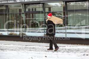 Man with cloth bag runs through the snow