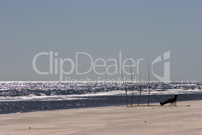 Single long fishing pole standing in sand at beach