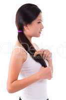 Side view Asian girl combing hair