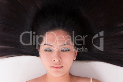 Asian girl lying on white with scatter hair