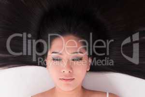 Asian girl lying on white with scatter hair