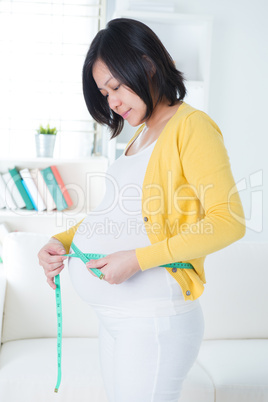 Asian woman measures her stomach