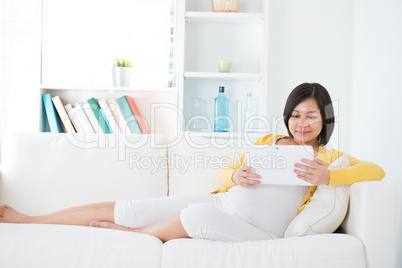 Asian  pregnant woman using tablet computer