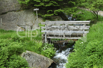 Wooden bridhe across a water stream