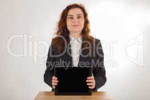 Eine junge Frau hält ihren Tablet-PC in die Kamera