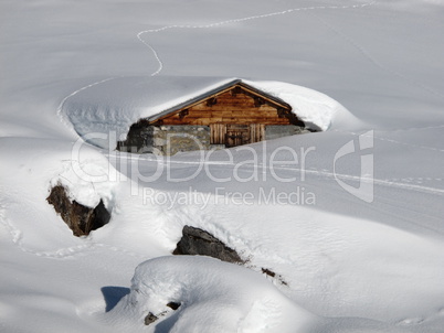 Timber hut nearly completely under the snow