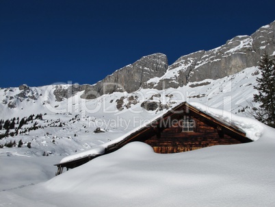 Old hut in the snow, mountains in Braunwald