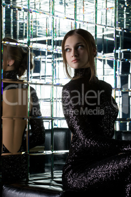 Pretty young girl in long dress near mirror