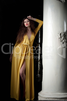 Pretty young woman posing near column