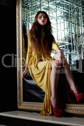 Pretty young woman in yellow fashion long dress