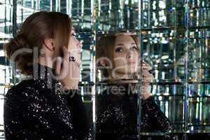 Beautiful woman in long black dress near mirror