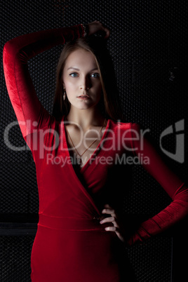 Beautiful young woman in red dress - dark room