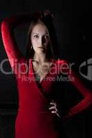 Beautiful young woman in red dress - dark room