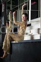 Young woman in gold dress have fun on bar table