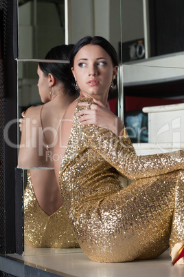 Beauty woman portrait in gold dress on stairs