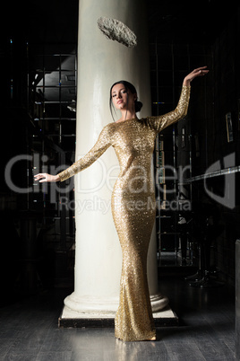 Fashion young woman in gold dress