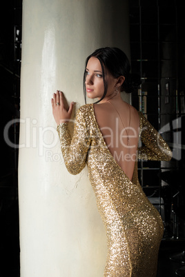 Beautiful brunette woman in gold dress