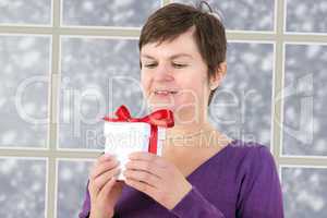 Woman with gift package is in before the snow window