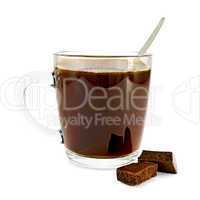 Coffee in glass mug with two slices of chocolate