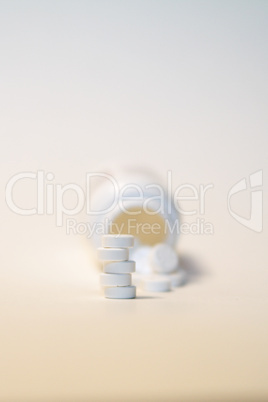 Stack of Pills in Front of Bottle