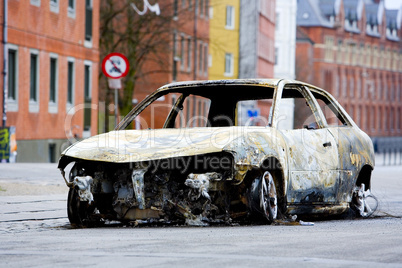 A burnt out car on the road