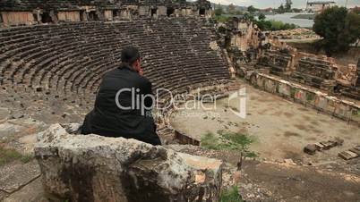 Man sitting on the stone chair in ancient amphitheater Myra
