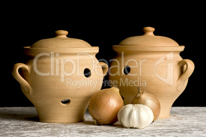 Two pots with onions and garlics