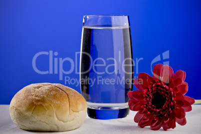 A soft roll and a glass of water