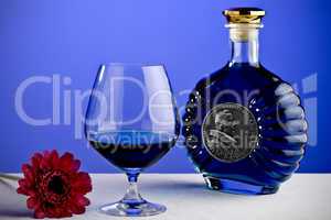 Cognac glass and bottle in blue lig