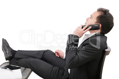 young business man relaxing at office desk and talking on mobile