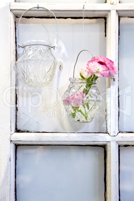 Two vases hung up on nails in the window