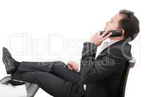 young business man relaxing at office desk and talking on mobile