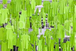 Green T-shirts hanging from the ceiling