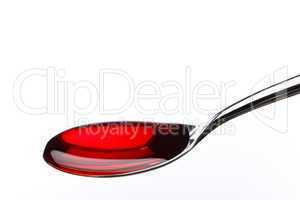 Spoon filled with red medicine