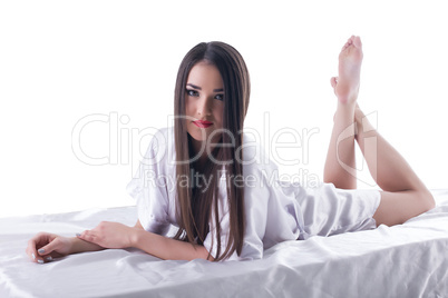young brunette woman with long hair posing on bed