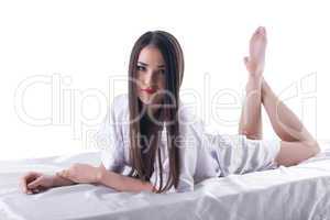 young brunette woman with long hair posing on bed