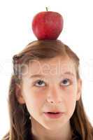 Konzeptbild: Mädchen hat einen Apfel auf dem Kopf