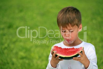 Junge isst Wassermelone und macht Flecken