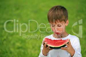 Junge isst Wassermelone und macht Flecken