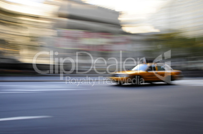 Taxi cab speeding down street in a