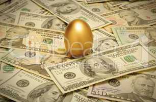 Gold nest egg on a layer of cash