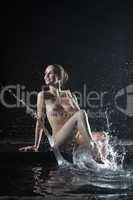 Beautiful nude young woman near water