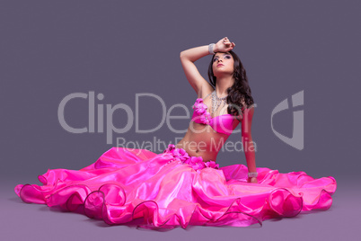 Beautiful dancer in pink costume  sitting on floor