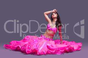 Beautiful dancer in pink costume  sitting on floor