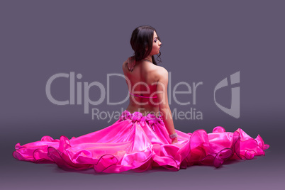 Dancer in pink costume sitting on floor