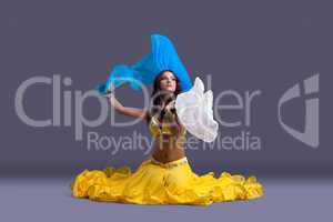 Beautiful dancer in yellow costume sit on floor