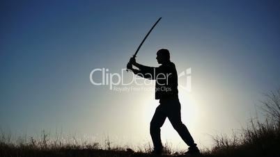 silhouette of guy practicing with sword