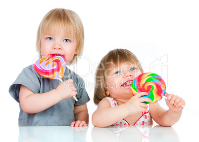 Babies eating a sticky lollipop