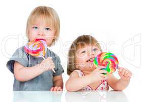 Babies eating a sticky lollipop